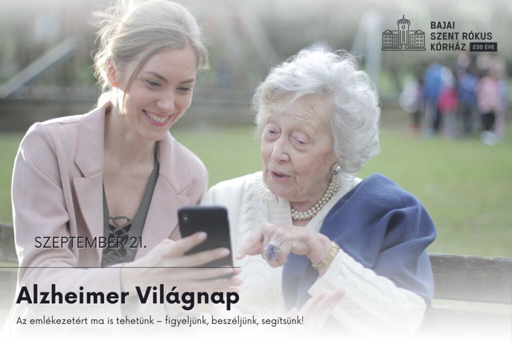 Alzheimer Világnap. Egy fiatalabb hölgy egy idősebb hölgynek mutat valamit telefonon.